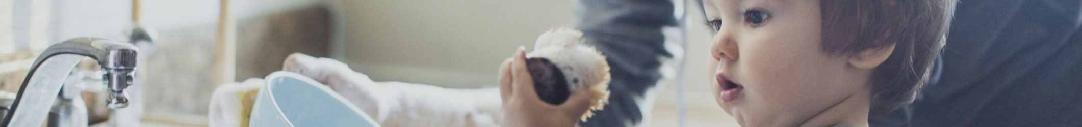 Close up of a boys face as he looks at a vacuum cleaner attachment